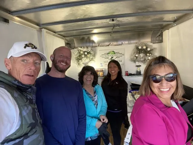 ARCM Cares volunteers serving holiday meals from the ARCM food trailer in Denver