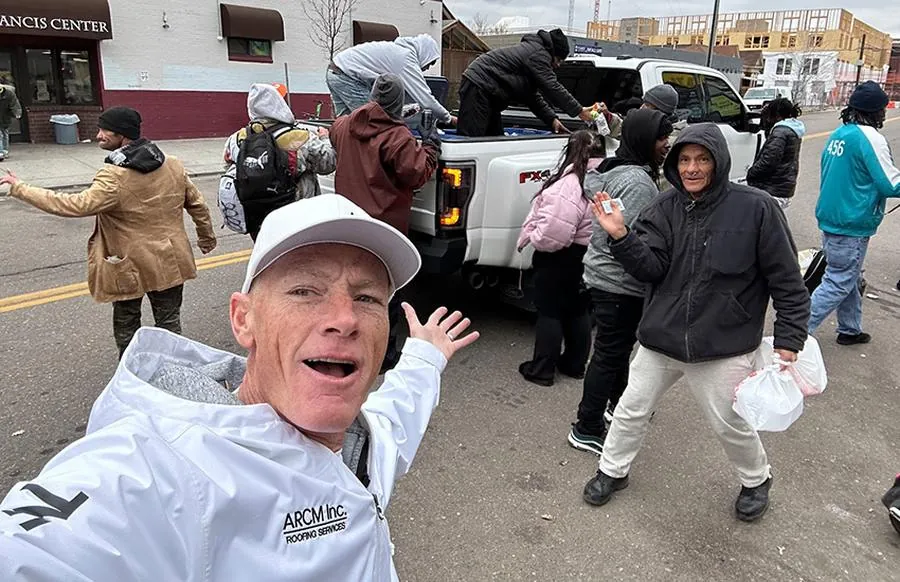 ARCM Roofing crew handing out free food and supplies to neighbors in need on a Denver street